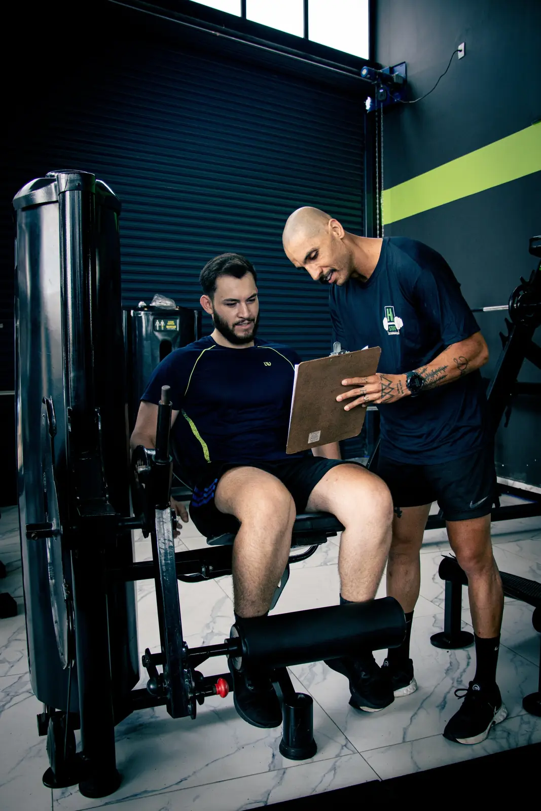 Treinador da HD STUDIO acompanhando aluno em exercício personalizado